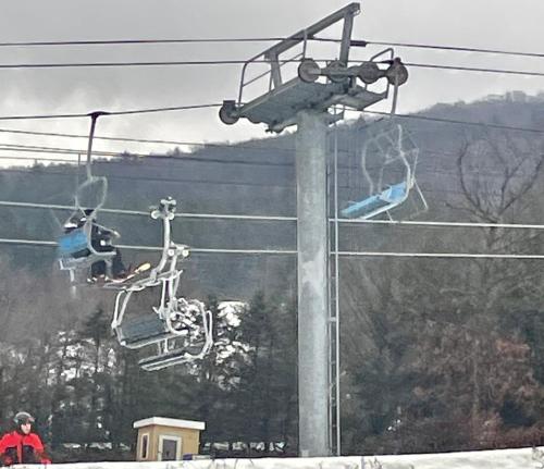 a ski lift with two people on it in the snow at Las margaritas in Allentown