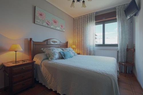 een slaapkamer met een bed en een raam bij El Mirador de San Vicente in San Vicente de la Barquera