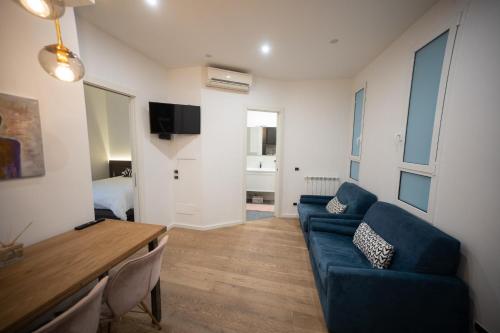 ローマにあるAngelico Luxury Houseの青いソファとテーブルのあるリビングルーム