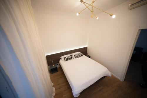 a bedroom with a white bed with two pillows on it at Angelico Luxury House in Rome