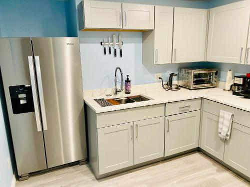 a kitchen with white cabinets and a stainless steel refrigerator at Artsy home by Air Force Academy with office space in Colorado Springs