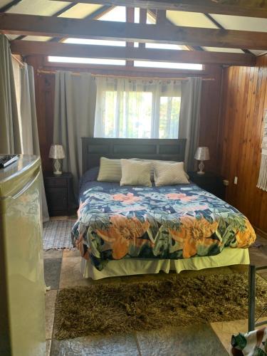 a bedroom with a bed with a colorful comforter at Cabanas Klenner in Puerto Varas