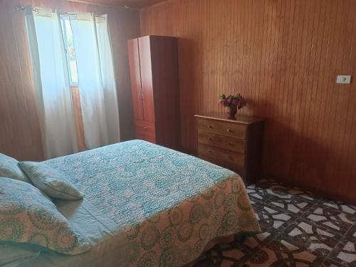 a bedroom with a bed with a dresser and a dresser at cabañas Te Pito Kura in Hanga Roa