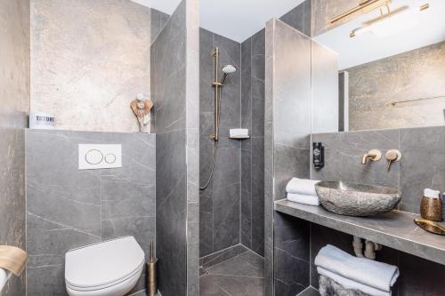 a bathroom with a shower and a toilet and a sink at Boutique-Pension Jägerwirt in Scheffau am Wilden Kaiser