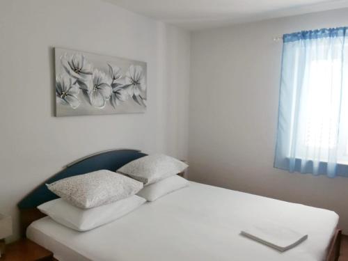 Apartment Tempera في بوفليا: سرير أبيض مع وسادتين في غرفة النوم