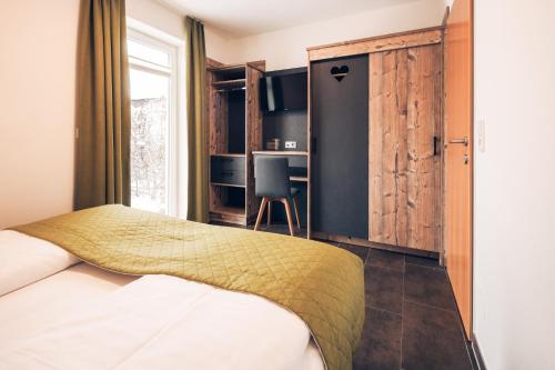 トレーポラッハにあるNassfeld-Appartementsのベッドルーム1室(ベッド1台、デスク、椅子付)