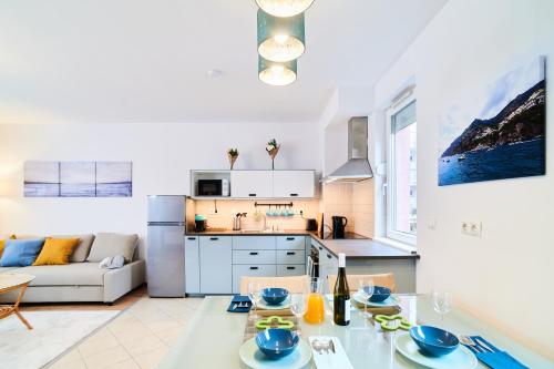 a kitchen and a living room with a table and chairs at FEEL HOME DeLuxe CORVIN -FREE PARKING-AC-Elevator in Budapest
