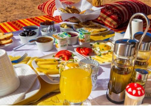 a table with breakfast foods and drinks on it at Fantastic Luxury Camp in Merzouga