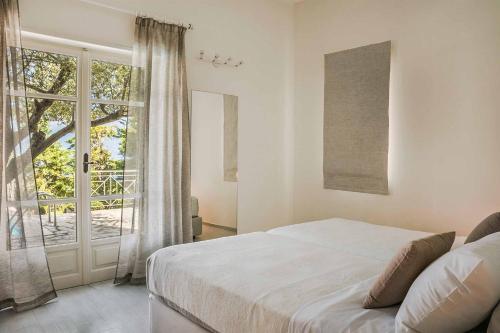 a bedroom with a bed and a large window at Villa Astria in Kefallonia