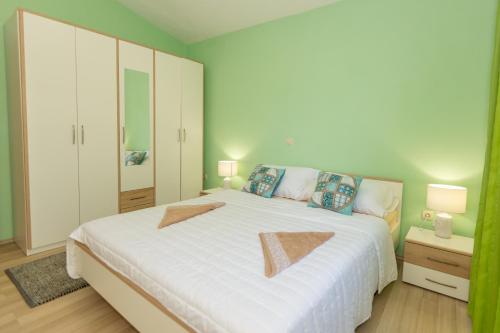 1 dormitorio con 1 cama blanca grande y 2 almohadas en Villa Green Oasis, en Žeževica