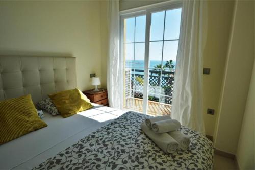 sypialnia z łóżkiem i oknem z widokiem w obiekcie Benalmadena Beach Apartamento con Vistas al mar y Parking Privado Incluido w mieście Benalmádena