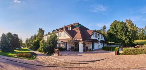 a large house on a street with a driveway at Motorest Melikana in Humpolec