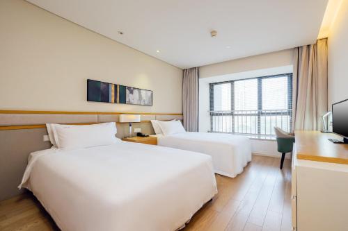 una camera d'albergo con 2 letti e una scrivania di Holiday Inn & Suites Suzhou Yangcheng Lake, an IHG Hotel a Suzhou