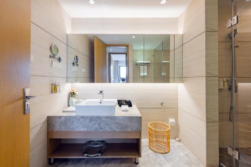 a bathroom with a sink and a mirror at Holiday Inn & Suites Suzhou Yangcheng Lake, an IHG Hotel in Suzhou