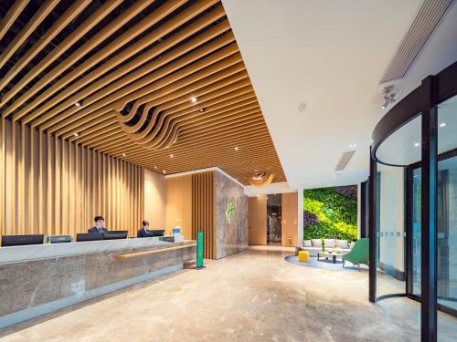 lobby z recepcją i biurkami w obiekcie Holiday Inn & Suites Suzhou Yangcheng Lake, an IHG Hotel w mieście Suzhou