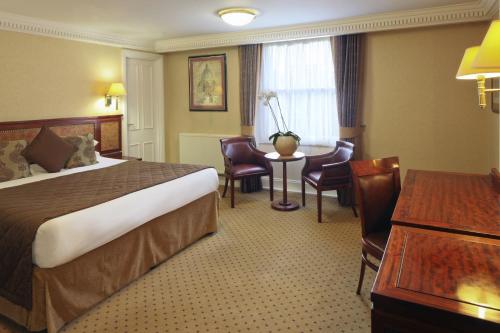 a hotel room with a bed and a table at Grange Portland Hotel in London