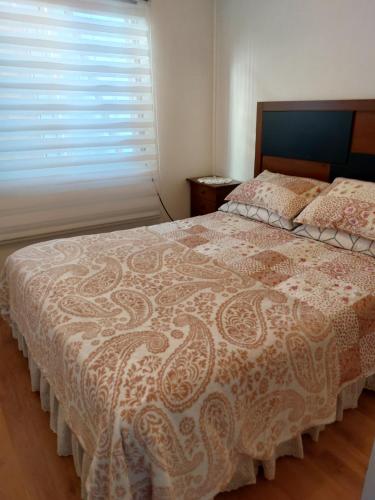 a bedroom with a large bed with a window at Casa a 5 minutos del balneario in Frutillar