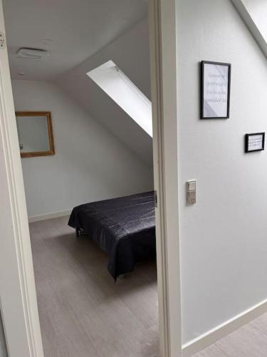 a bedroom with a bed in a white room at 3 værelses lejlighed med hems - 4 in Kolding