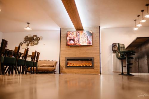 Una sala de estar con chimenea y televisión. en Valea Putnei Residence- Rooms for rent, en Valea Putnei