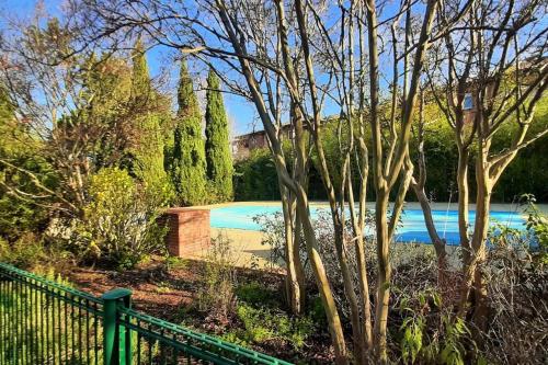 une piscine à côté d'une clôture et d'arbres dans l'établissement Studio charmant et moderne grand confort, à Toulouse