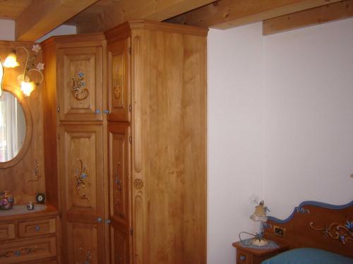a bedroom with wooden cabinets and a bed at Auronzo Vacanze di Marina e Valter - Corte 12 in Auronzo di Cadore