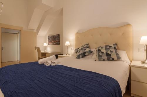 sypialnia z dużym łóżkiem i niebieskim kocem w obiekcie Konporte, Vivienda Turística Renovada con Wifi y Garaje w mieście Getxo