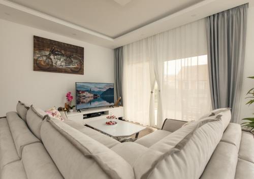 a living room with a large couch and a table at Apartmani Pravilovic II in Bijela