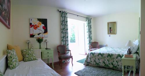 a bedroom with two beds and a desk and a window at Le Presbytère de Vieuvy 