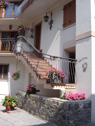 a building with a staircase with flowers on it at Appartamento "Tudaio" - Corte 12 in Auronzo di Cadore