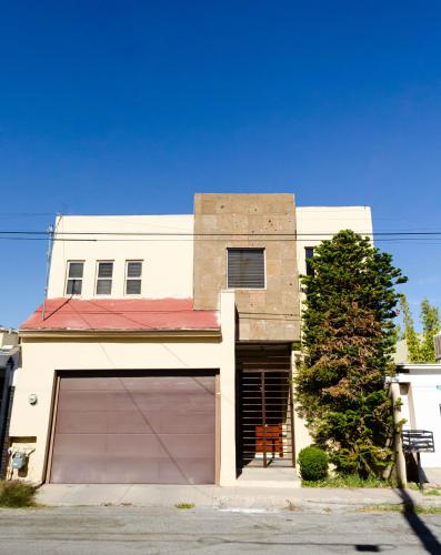 a large white house with a large garage at Alojamiento completo 3 habitaciones (se puede facturar) in Chihuahua