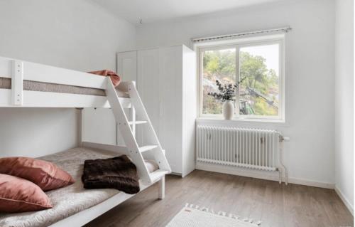 斯特倫斯塔德的住宿－Cheerful Three room villa at Strömstad City Center，白色的卧室设有双层床和窗户。