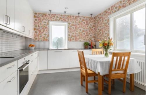 斯特倫斯塔德的住宿－Cheerful Three room villa at Strömstad City Center，厨房配有桌椅和窗户。