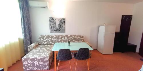 uma sala de estar com um sofá, uma mesa e cadeiras em Seaview apartment - Clara Sarafovo - 100m to sea em Burgas
