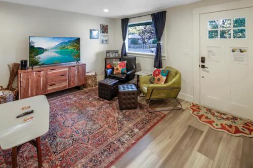 a living room with a tv and a couch and a chair at VogueTown in Boise