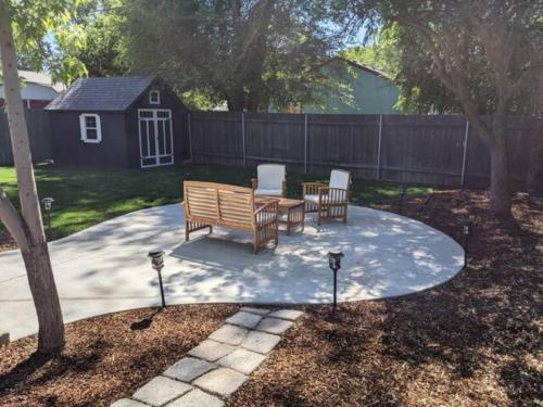 a patio with chairs and a table and a fence at Little Blue Bungalow on Boise's Bench, Pet Friendly, Fully Fenced yard with doggie door! 2 miles from BSU, 5 minutes from Downtown Boise, Desk and workstation for remote workers, 2 TV's large walk-in closet, Good for mid-term stays in Boise