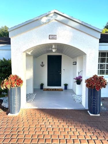 two vases with flowers in them in front of a door at Home in Miami in Miami