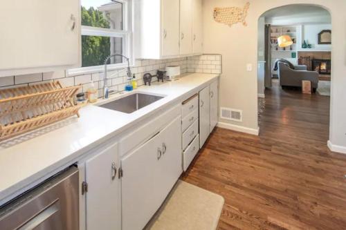 a kitchen with white cabinets and a sink at Celebration Chalet! Quant, cozy, a few blocks from BSU and close to downtown Boise, Fireplace, 4 beds, and seating for 6 Pets Welcome! in Boise