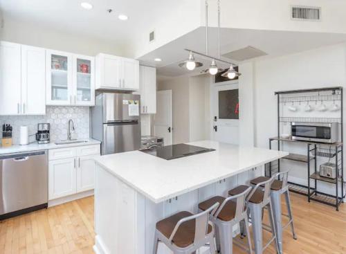 a kitchen with white cabinets and a white counter top at Downtown Digs-View of the City! Stay above local restaurants and nightlife, posh amenities heated toilet seat, oversized rain shower head in glass shower, in-unit laundry, one garage parking spot in Boise