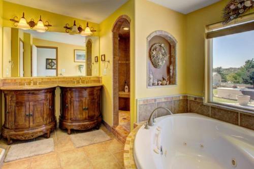baño grande con bañera y espejo grande en Mountain View Retreat in Nampa! Million dollar views from the panoramic windows, 6 bedrooms! Sleeps 14! Have your wedding or family reunion or retreat here on our hillside, en Nampa