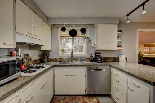 a kitchen with white cabinets and a sink at Sunset Home perfect for extended stays with fully fenced in yard, designated office, two living rooms, located across from Boise Foothills and close to Bogus Basin in Boise's North End in Boise