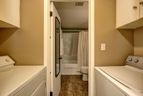 a small bathroom with a toilet and a shower at Sunset Home perfect for extended stays with fully fenced in yard, designated office, two living rooms, located across from Boise Foothills and close to Bogus Basin in Boise's North End in Boise