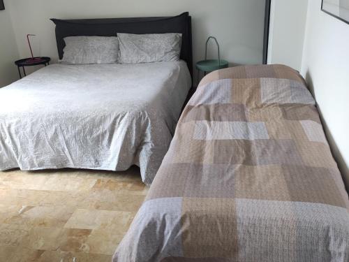 een slaapkamer met 2 bedden en een houten vloer bij Andaleppo in Mestre