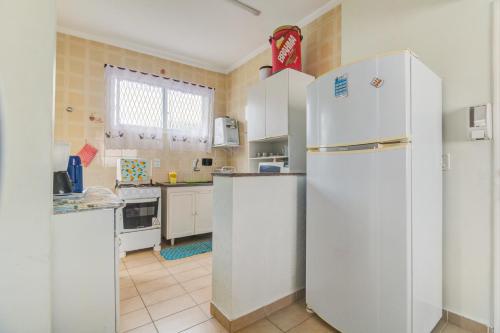 uma cozinha com electrodomésticos brancos e um frigorífico branco em Cobertura duplex c/piscina privativa,Praia Enseada no Guarujá