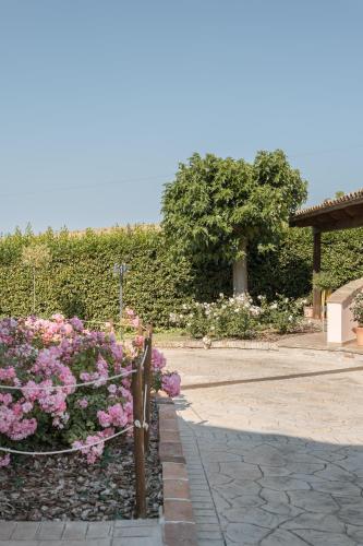 a garden with pink flowers and a fence at B&B Casa Fanny Riviera Del Conero in Loreto