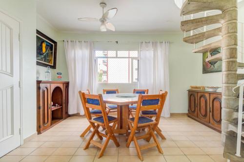 una sala da pranzo con tavolo e sedie di Cobertura duplex c/piscina privativa,Praia Enseada a Guarujá