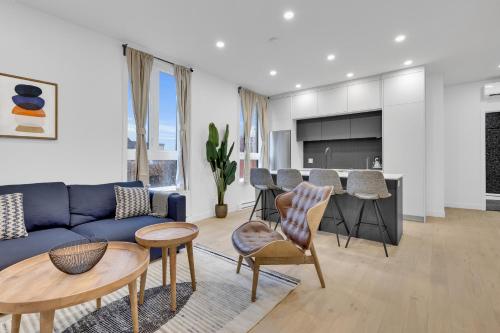 ein Wohnzimmer mit einem blauen Sofa und einem Tisch in der Unterkunft Deluxe Suites Downtown Montreal in Montreal