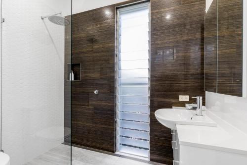 a bathroom with a glass shower and a sink at Studio 9 in Byron Bay