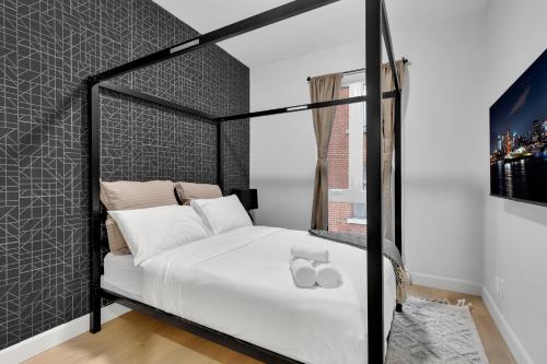 a bedroom with a black canopy bed with white pillows at Deluxe Suites Downtown Montreal in Montréal