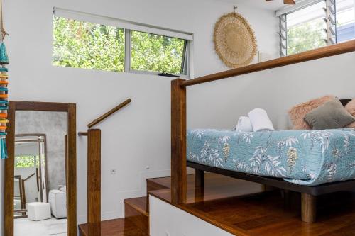 a living room with a bed and a mirror at Studio 9 in Byron Bay