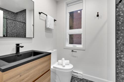 a white bathroom with a sink and a toilet at Deluxe Suites Downtown Montreal in Montréal